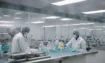 Scientists wearing masks in a lab conducting tests.