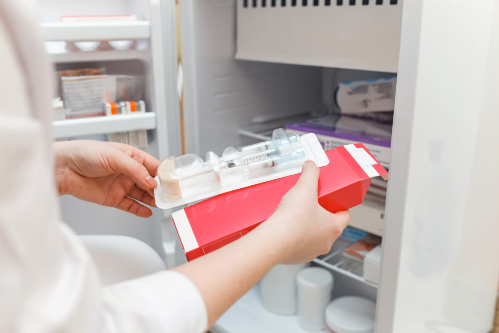 Person removing blood transfusion from a freezer unit